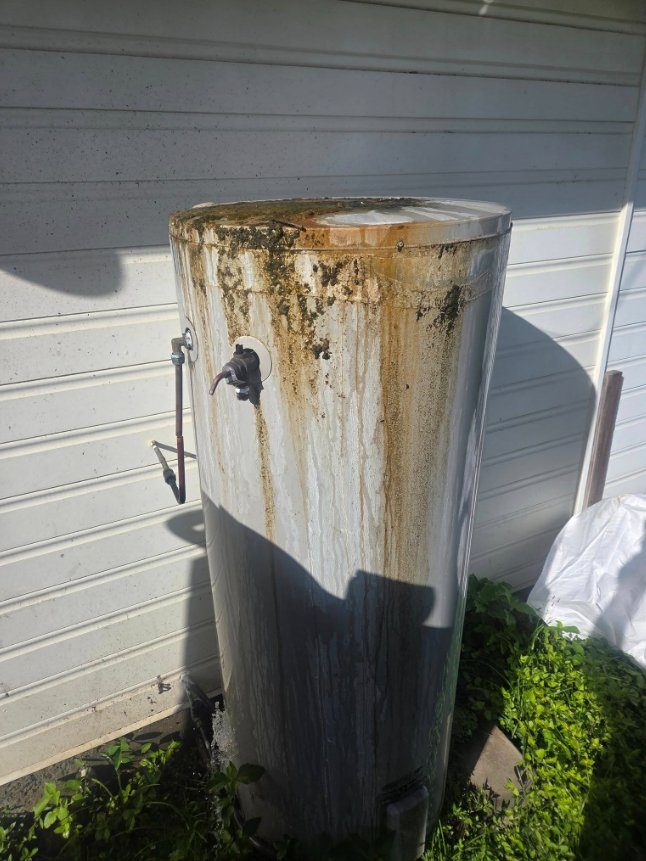Old rusted failing hot water system before replacement